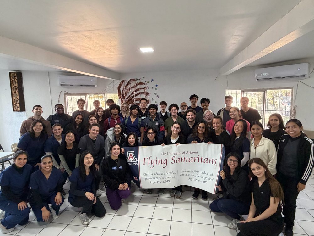 University of Arizona Flying Samaritans team in Agua Prieta, MX, holding a banner that reads Providing free medical and dental services for the people of Agua Prieta